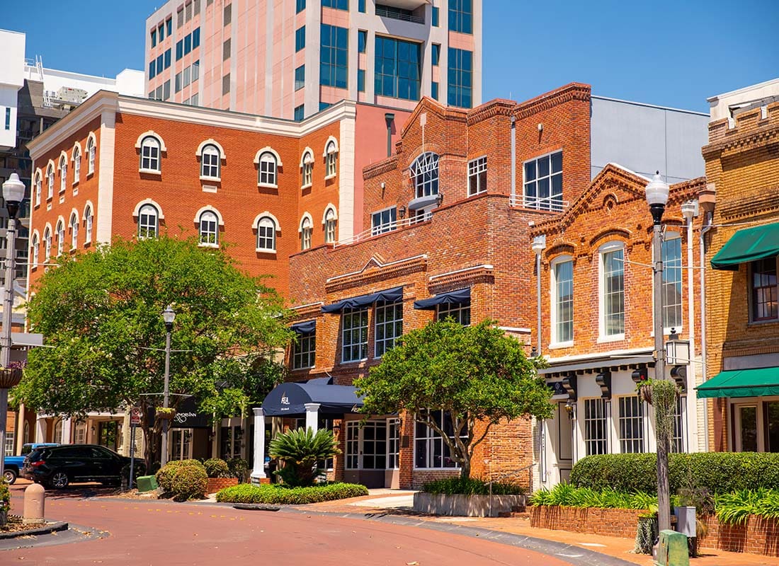 Contact - Row of Red Brick Buildings Surrounded by Green Foliage in Downtown Tallahassee Florida on a Sunny Day