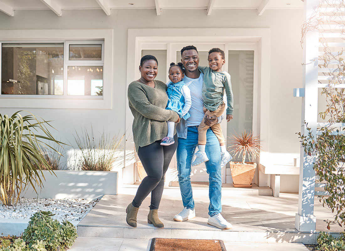 Personal Insurance - Portrait of a Smiling Family with a Son and Daughter Standing in the Back Patio of Their New Home on a Sunny Day