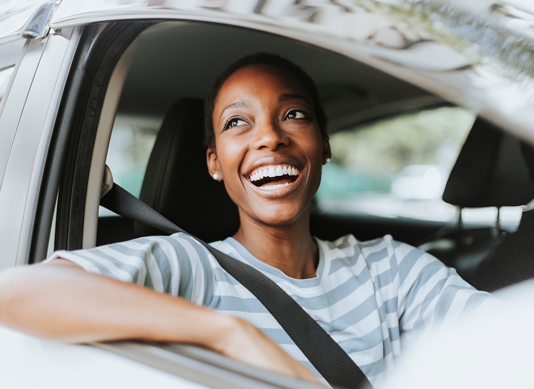 Service Center - Closeup Portrait of a Cheerful Young African American Woman Sitting in the Passenger Seat of a Car